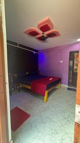 a bedroom with a bed with a ceiling fan at Green home stay in Ankola