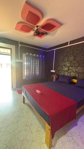 a bedroom with a large bed with a ceiling fan at Green home stay in Ankola