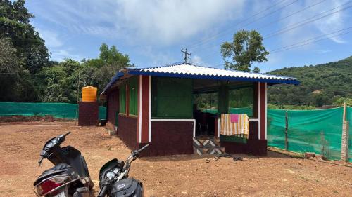 a motorcycle parked in front of a small building at Green home stay in Ankola