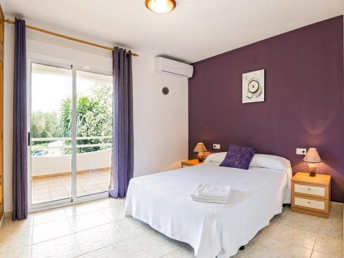 a bedroom with a large bed and a balcony at Apartamento Esmeralda VyB in Denia