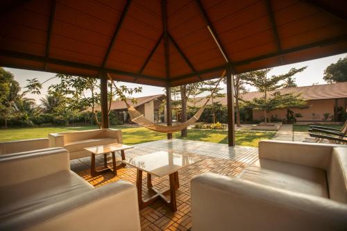 a living room with couches and a hammock at Tropica by CBR Farms in Nandigunda