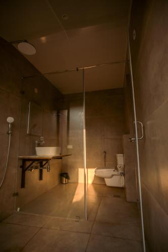 a bathroom with a shower and a sink and a toilet at Tropica by CBR Farms in Nandigunda