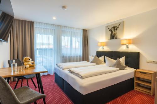 a hotel room with a bed and a desk at Familienhotel Löwen in Nesselwang