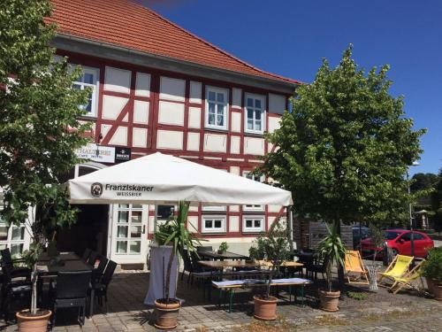 a building with an umbrella and tables and chairs at Hotel Alte Posthalterei in Creuzburg