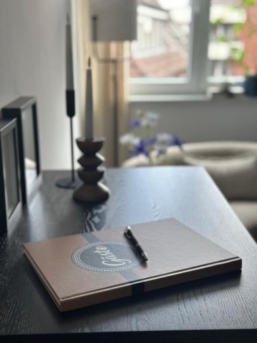a notebook with a pen on top of a table at Emils City Suite in Vreden