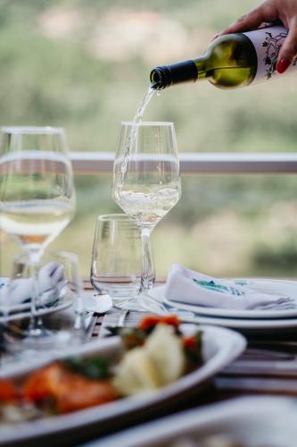 a person pouring a glass of wine on a table at Welcome Douro - Eco Camping Resort in Cinfães