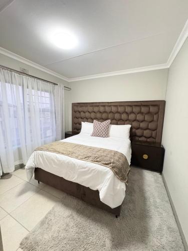 a bedroom with a large bed and a large window at Zambezi luxe stay in Pretoria