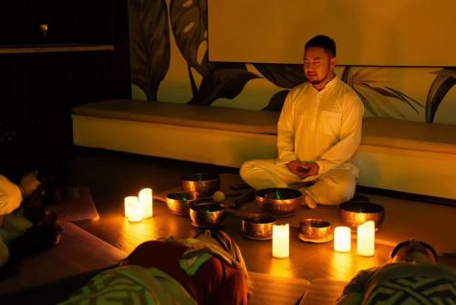 a man is sitting on a bed with candles at Dasein Youlan Hotel-Near the Forbidden City, Tiananmen Square, Guijie Street, Beihai Park, Jingshan Park, and Yonghe Temple in Beijing