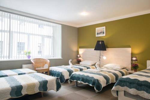 3 camas en una habitación con paredes y ventanas verdes en Nostalgia, en Riga