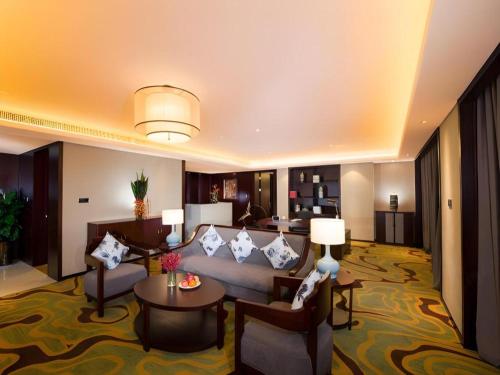 a hotel room with a couch and a table at New Century Grand Hotel Xi'an Xizang Building in Xi'an