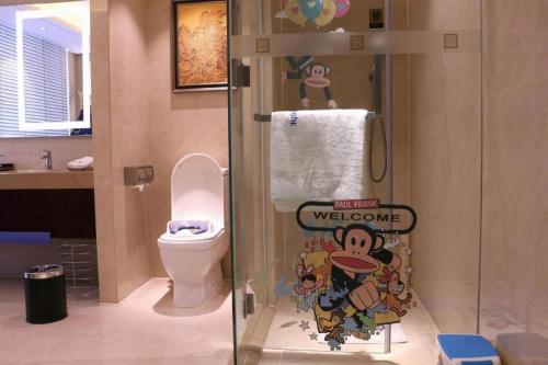 a bathroom with a toilet and a shower with a welcome sign at New Century Grand Hotel Xi'an Xizang Building in Xi'an