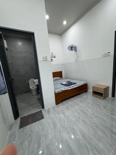 a small bathroom with a bed and a shower at Phú Vinh Motel in Cao Lãnh