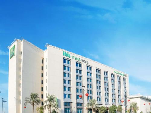 a large white building with the las vegas hotel at Ibis Styles Dragon Mart Dubai in Dubai