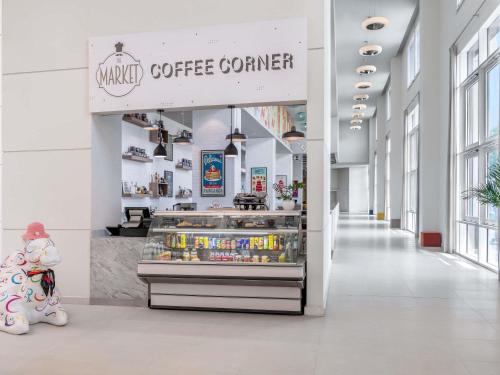 a bakery with a coffee counter in a building at Ibis Styles Dragon Mart Dubai in Dubai