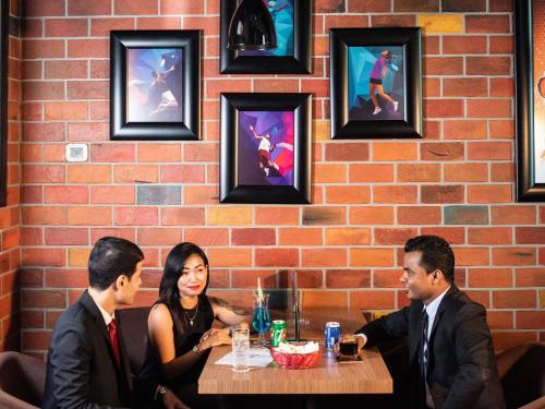 a group of people sitting at a table in a restaurant at Ibis Styles Dragon Mart Dubai in Dubai