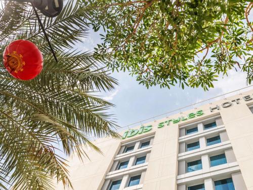 a building with a red ball hanging from a palm tree at Ibis Styles Dragon Mart Dubai in Dubai