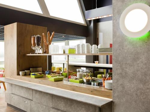 a kitchen with a counter with plates and dishes at ibis budget Pontault Combault RN4 Marne La Vallée in Pontault-Combault