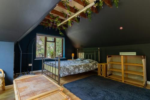 a bedroom with a bed and a blue wall at 600 Year Old Toddbrook Barn Sleeps 11 in Great Parndon