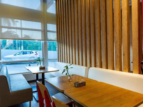 a dining room with a table and a car outside a window at ibis Manaus Aeroporto in Manaus