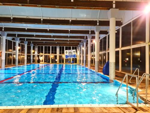 a large indoor swimming pool with blue water at Rose Suite in Caesarea