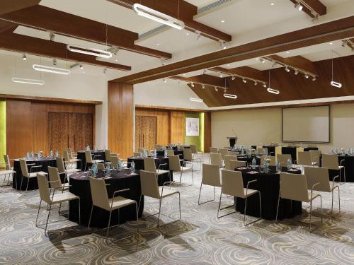 a conference room with tables and chairs and a screen at ibis Styles Goa Calangute - An Accor Brand in Calangute