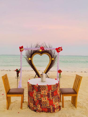 a table with a heart shaped altar on the beach at Royal Mandarin Hotel & Resort in Pwani Mchangani