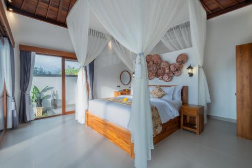 a bedroom with a canopy bed in a villa at Mahayani Ubud Villa in Tegalalang