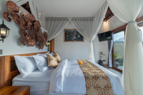 a bedroom with a white bed and a window at Mahayani Ubud Villa in Tegalalang