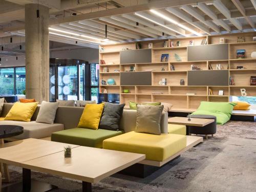 a room with a couch and tables and shelves at Novotel Wrocław Centrum in Wrocław