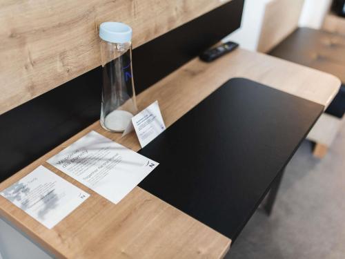 a wooden table with a vase on top of it at Novotel Wrocław Centrum in Wrocław