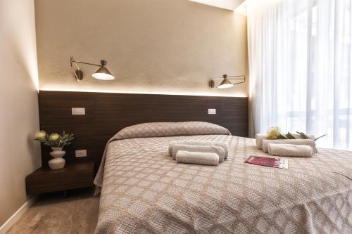 a bedroom with a large bed with two pillows at Valentino Rooms in Ravenna
