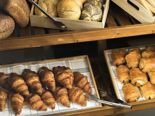 a display case with lots of different types of bread at Novotel Wrocław Centrum in Wrocław