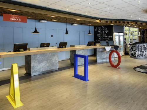 a lobby with a desk with laptops on it at ibis Fortaleza Centro de Eventos in Fortaleza