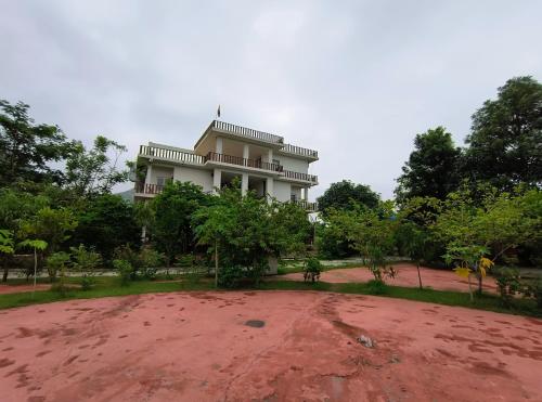 a large white building with a lot of trees at Jhar aravali in Jaipur