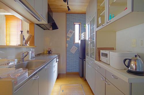 a kitchen with white cabinets and a sink at Nagoya Apricot House Entire Villa in Nagoya
