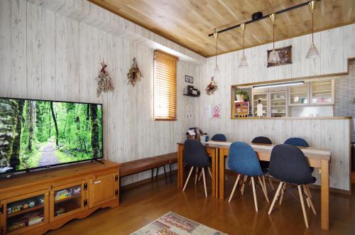 a living room with a television and a table and chairs at Nagoya Apricot House Entire Villa in Nagoya