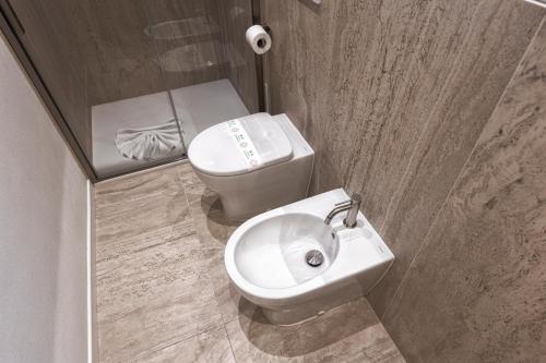 a bathroom with a toilet and a sink at Valentino Rooms in Ravenna