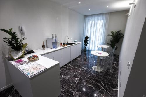 a kitchen with marble flooring and a white counter top at Valentino Rooms in Ravenna