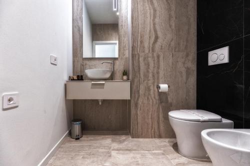 a bathroom with a white toilet and a sink at Valentino Rooms in Ravenna