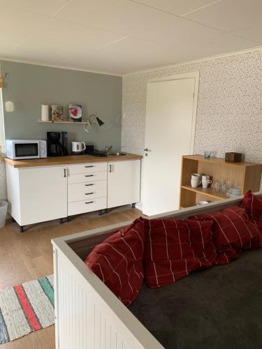 a living room with a couch and a kitchen at Gårdshus 1 in Örby
