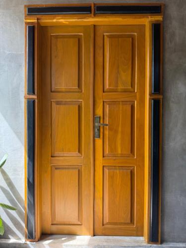 an open wooden door on the side of a building at Little jay"s villa in Batigama