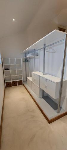 a large room with white counters and shelves in a room at Villa Sunniva in Mahébourg