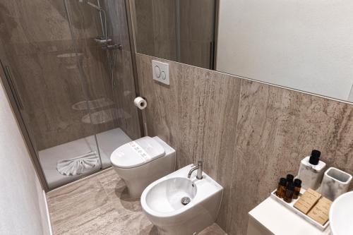 a bathroom with a toilet and a sink and a shower at Valentino Rooms in Ravenna