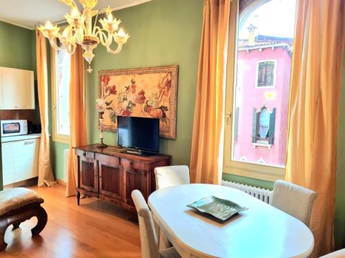 a living room with a table and a television at Allegretto Rialto in Venice