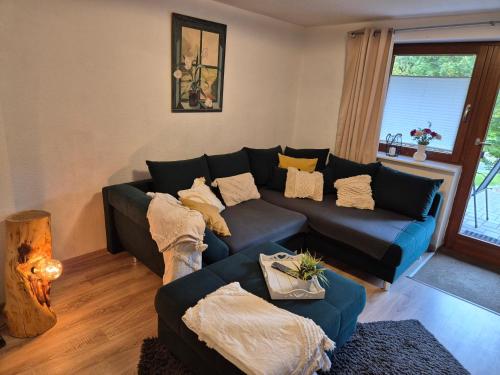 a living room with a blue couch with pillows at Ferien - und Monteurwohnung Stender im Sauerland in Schmallenberg