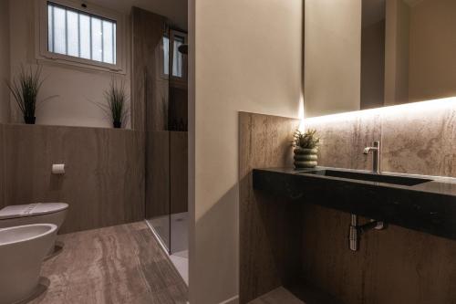 a bathroom with a sink and a toilet at Valentino Rooms in Ravenna