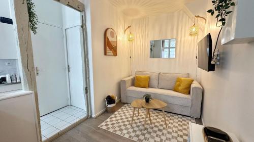 a living room with a couch and a table at Studio Cosy & bohème - Quartier Cauchoise in Rouen
