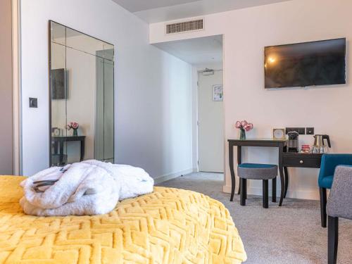 a bedroom with a bed and a desk and a television at Mercure Paris Saint Cloud Hippodrome in Saint-Cloud