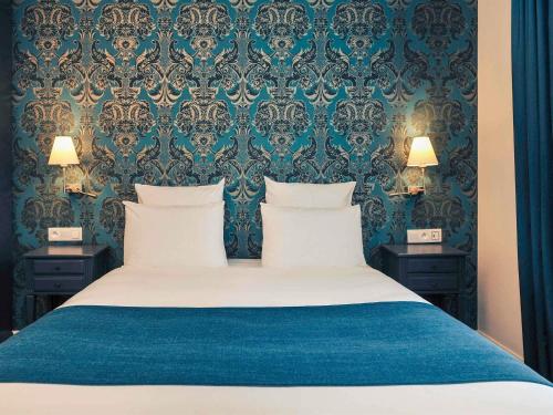 a bedroom with a large bed with two night stands at Mercure Paris Saint Cloud Hippodrome in Saint-Cloud