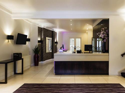 a hair salon with a reception desk and a mirror at Mercure Aberdeen Caledonian Hotel in Aberdeen